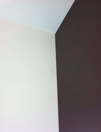 Angle entre un mur beige et un mur marron, avec des textures douces.